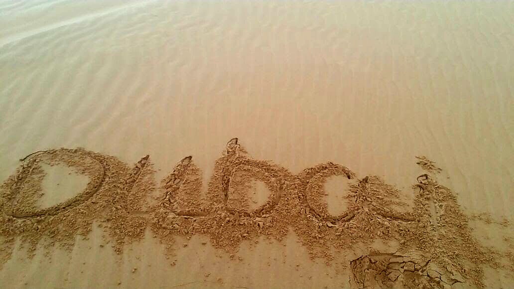 Dubai written in beach sand